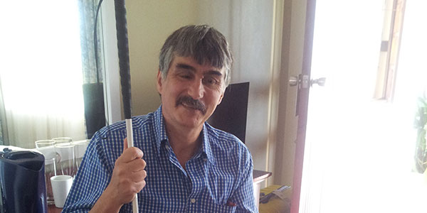 Pieter with his long cane smiling at the camera
